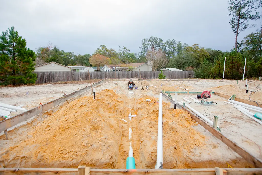 Townhome foundations, underground utilities and crews working during the Azalea Square buildout
